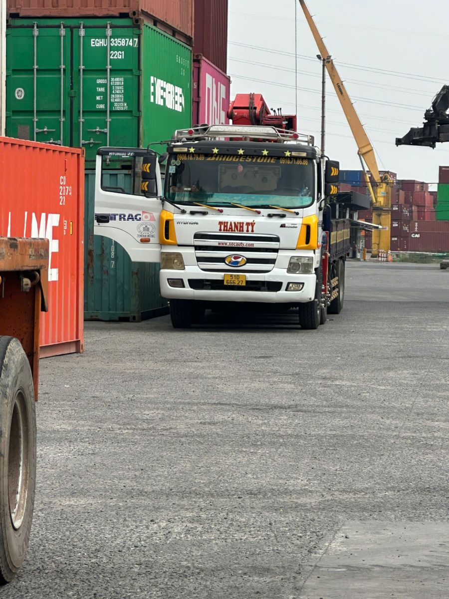 Công nhân đang sử dụng xe nâng để rút hàng hóa từ trong container ra ngoài kho